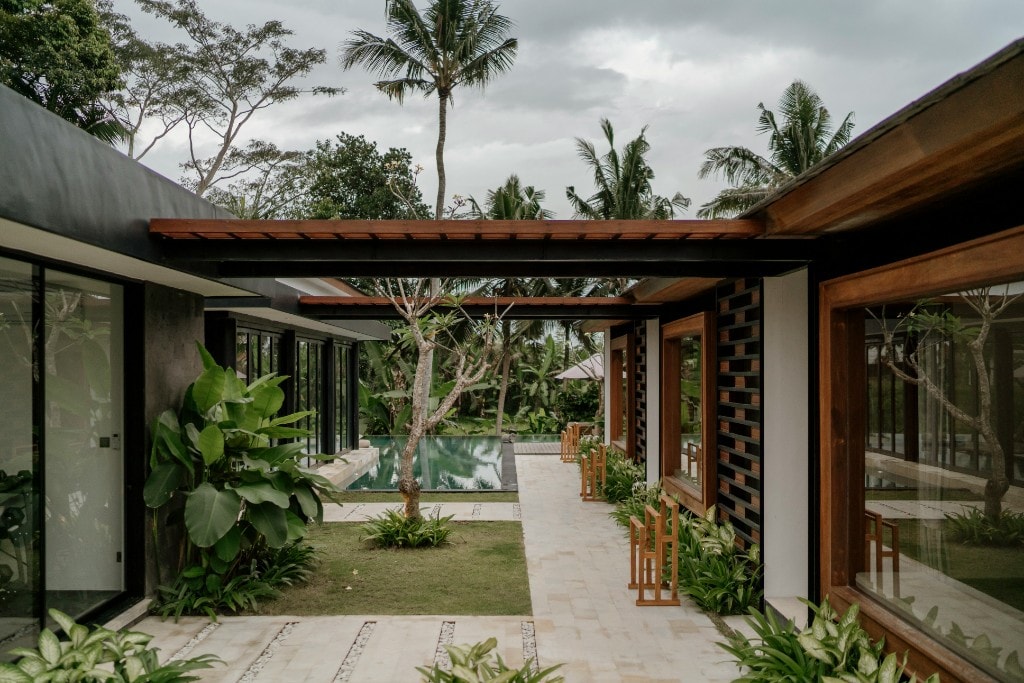 An open tropical villa framed beneath a canopy of palms